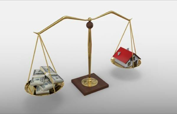 Money and a small house balancing on a scale, representing average mortgage payments in your state